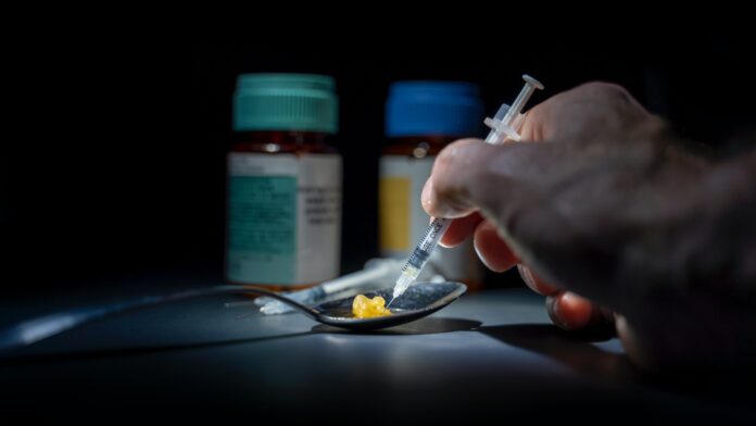 This is a photo of a spoon with drugs and a needle