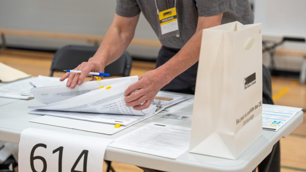 Poll worker serving an elector.