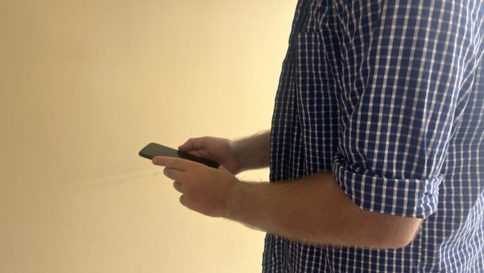 This is a photo of a man holding a cell phone.