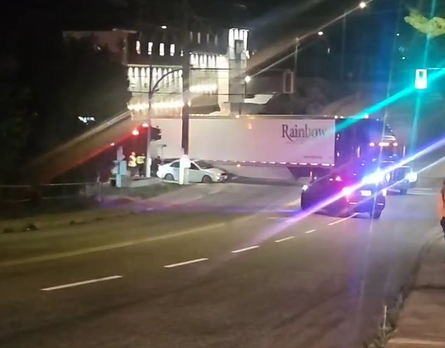 This is a photo of a sedan trpped under a semi trailer in Nelson