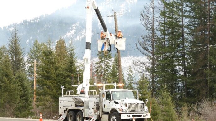 This is a photo of FortisBC power line technicians fix power lines following a winter storm in the Kootenays.
